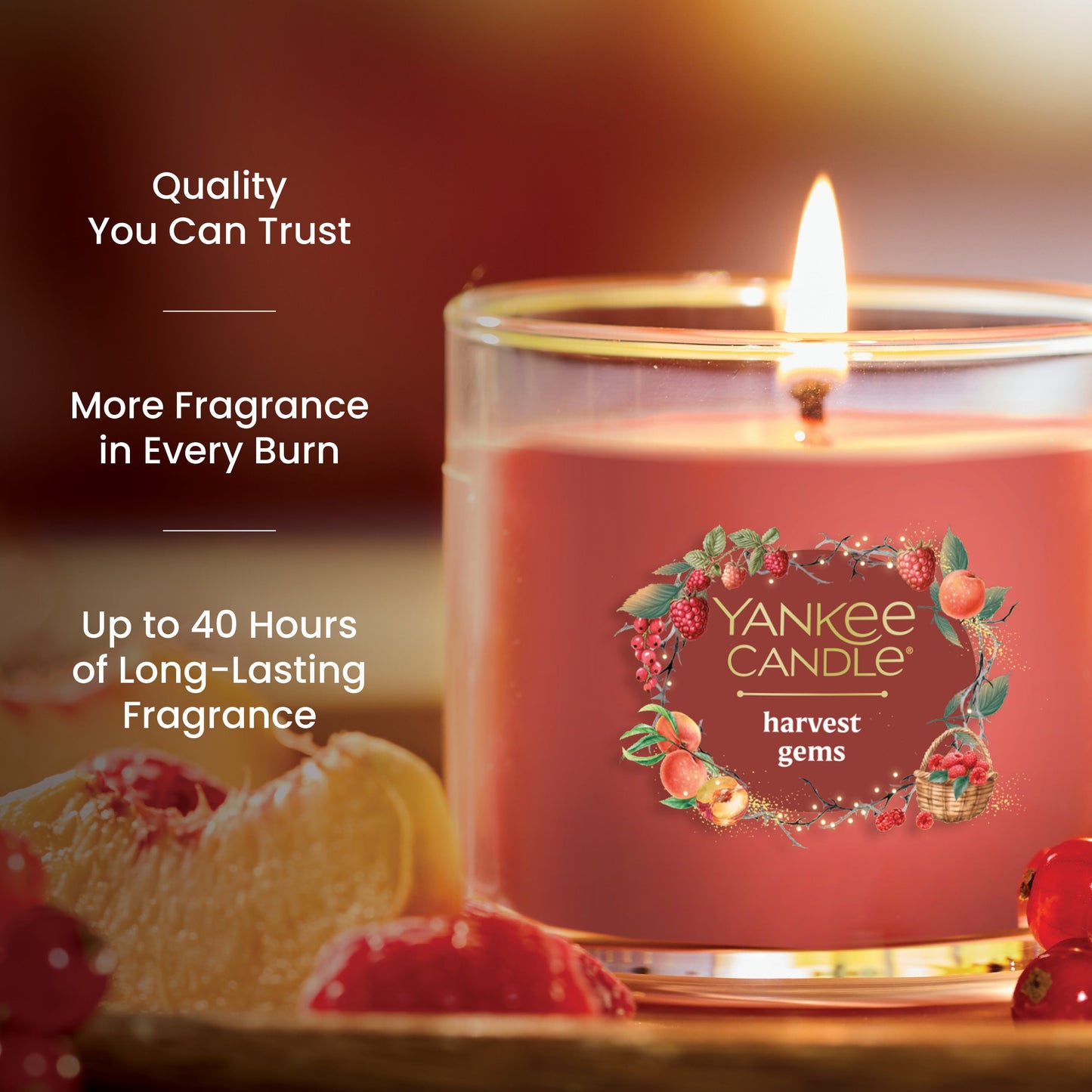 Red glass jar candle with fruit accents, promises up to 40 hours of long-lasting, quality fragrance burn time